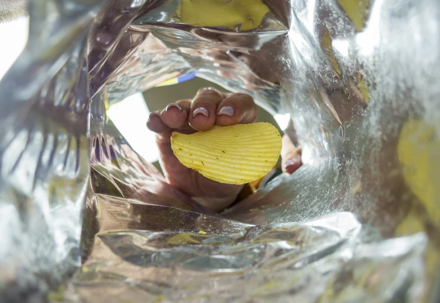 A hand reaching into a snack bag